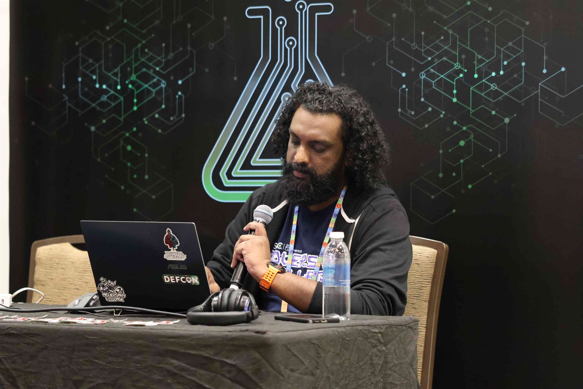 Abhijith B R presenting at DEF CON Singapore 2026 Demo Labs, Tactical Adversary sticker on his laptop